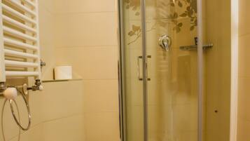 A bathroom with a glass-enclosed shower, a toilet, and a bidet.