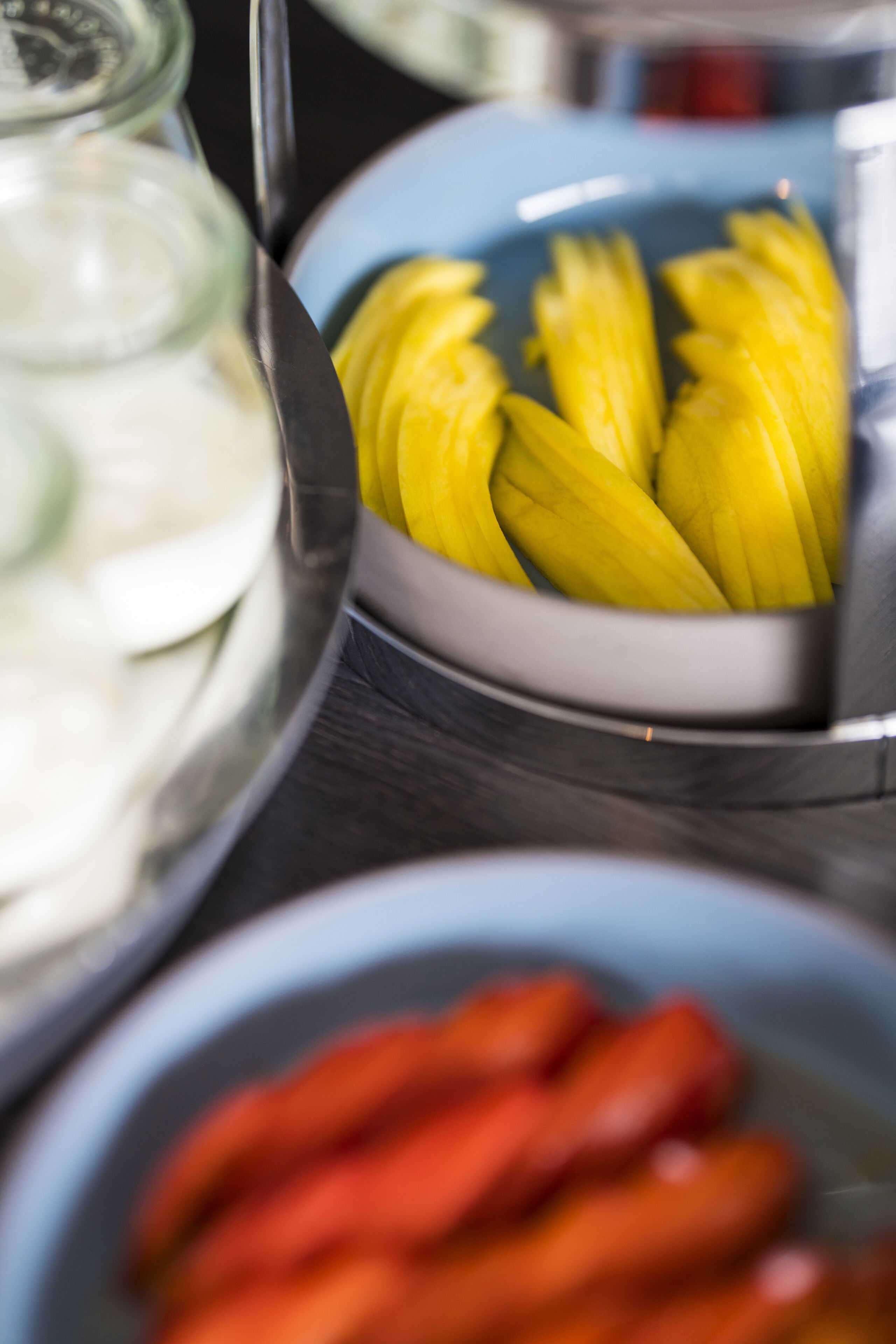 Een buffet met verschillende soorten eten, waaronder plakjes banaan en rode paprika.