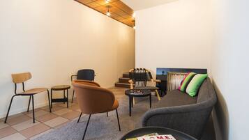 Een moderne woonkamer met een bank, fauteuils, een salontafel en een tijdschrift op de tafel.