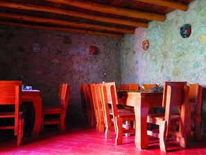 Un comedor rústico con mobiliario de madera y paredes de piedra.