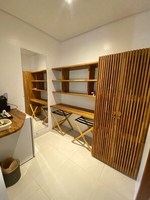 A compact storage room with wooden shelves and a foldable desk. - Pousada do Vale (Fernando de Noronha)