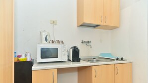 Une cuisine compacte équipée d’un four à micro-ondes, d’un grille-pain et d’un évier.