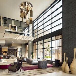 A spacious lobby with a high ceiling, large windows, and a modern chandelier. - Courtyard Phoenix Downtown (Phoenix)