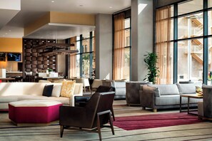 A spacious lobby with a sectional sofa, armchairs, and a red rug. - Courtyard Phoenix Downtown (Phoenix)