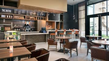 En moderne bistro med barområde, siddepladser og et stort vindue med udsigt.