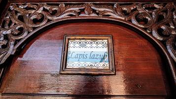 Una puerta de madera con un marco tallado ornamentado y un letrero que dice 'Lapis lazuli'.