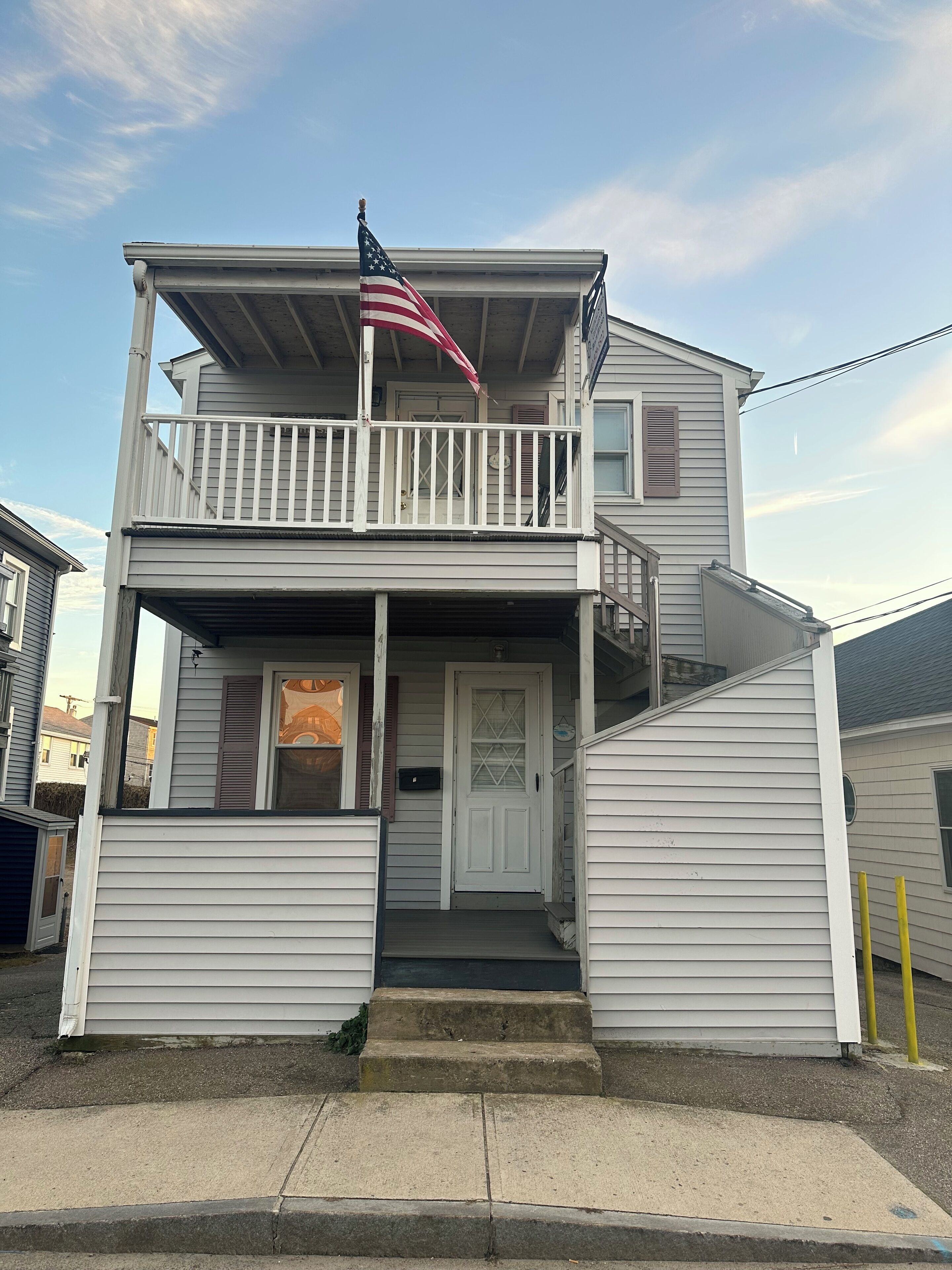 A two-story house with a balcony, a front door, and a small porch.