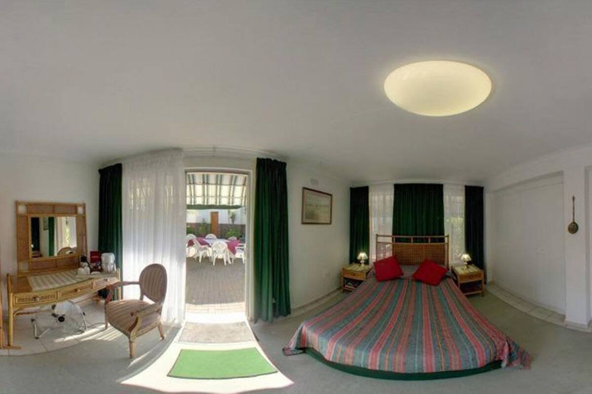 Ein geräumiges Schlafzimmer mit einem großen Bett, einem Schreibtisch und einem Stuhl.