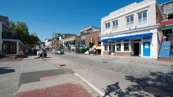 A street view with buildings, a clear sky, and a cobblestone road.