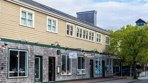 A two-story building with a cafe named 'Ben & Jerry's' on the ground floor and a shop named 'Kaffeology' on the second floor. - The Newport Lofts - 359 Thames Street (Newport)