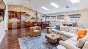 A spacious living area with a kitchen, a sofa set, and a coffee table. - The Newport Lofts - 359 Thames Street (Newport)