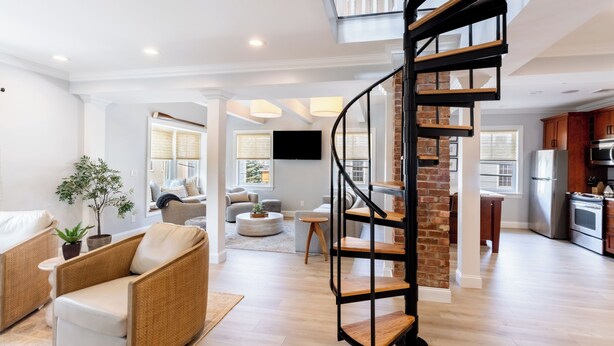 Un espacio habitable amplio con una escalera moderna, una cocina y un comedor.