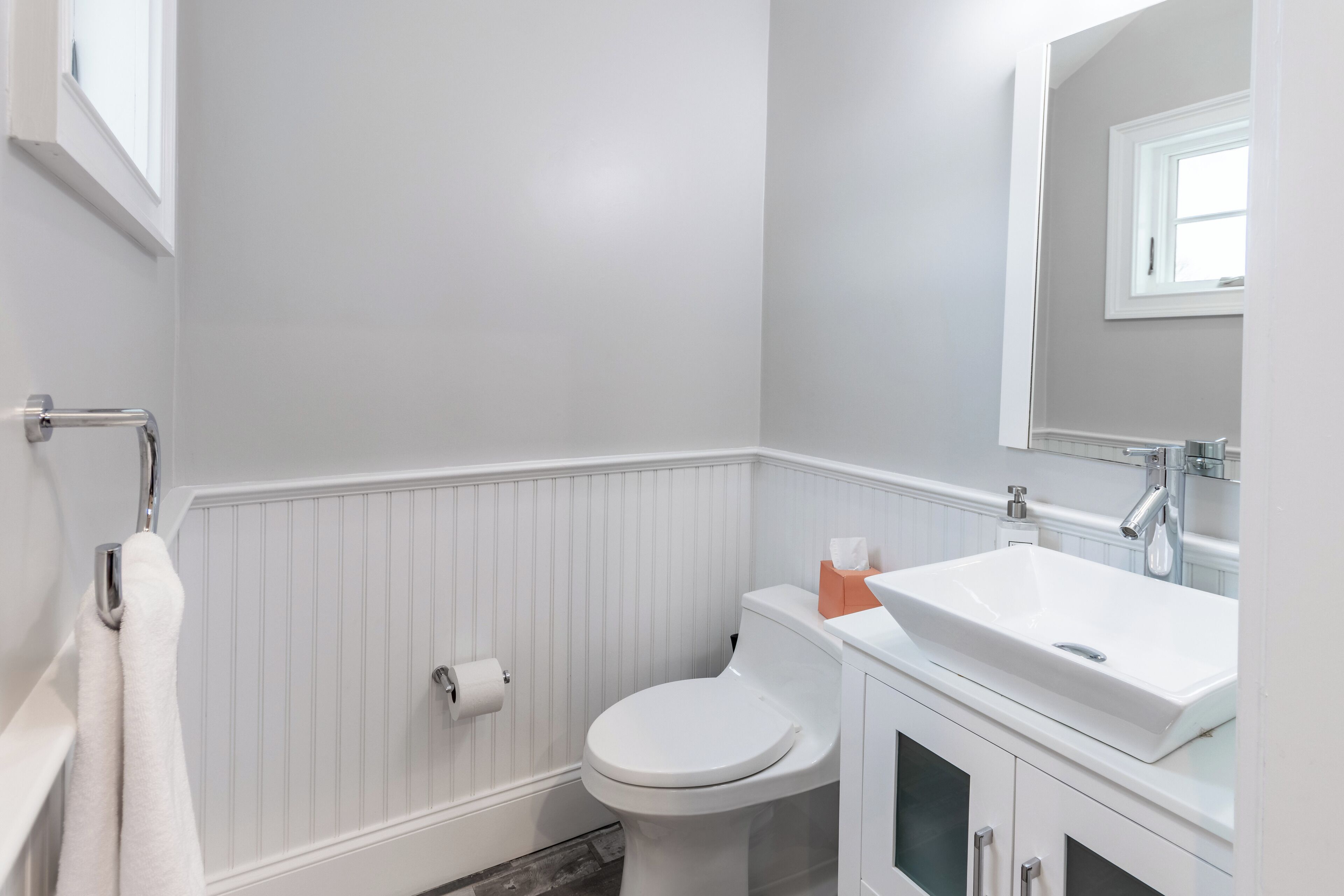 Une salle de bain équipée de toilettes, d’un lavabo et d’un porte-serviettes.