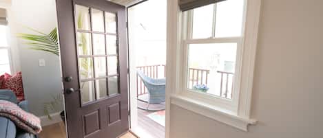 An open door leading to a balcony with a chair and a table.
