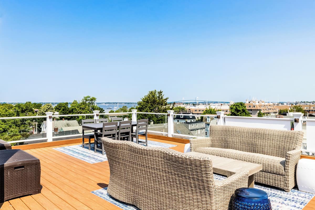 Terraza con mobiliario de mimbre, una mesa y vista al horizonte de la ciudad.