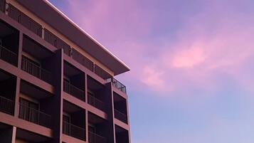 Un edificio de varios pisos con balcones, bajo un cielo despejado.