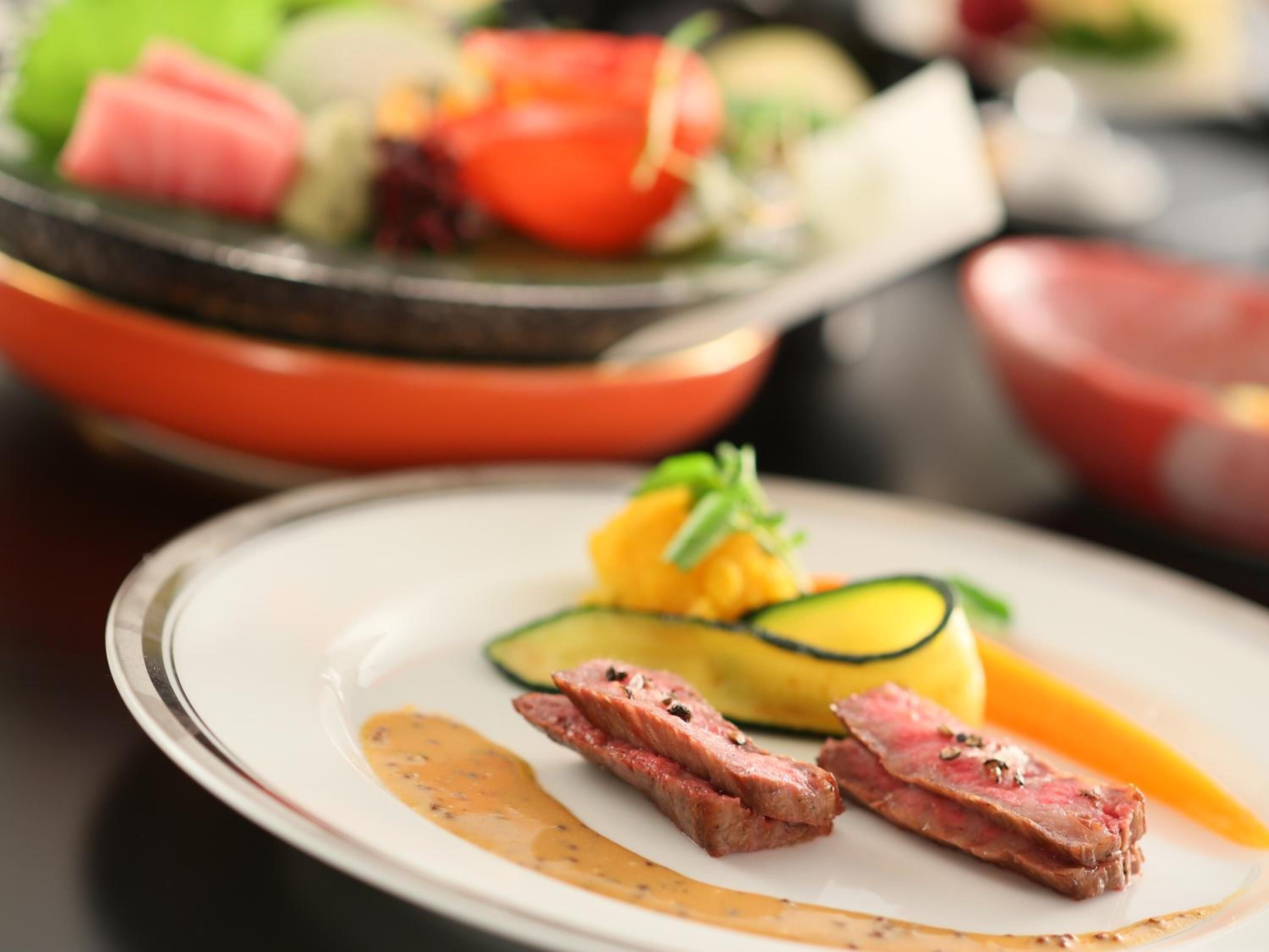 A plate with sliced meat, avocado, and a sauce.