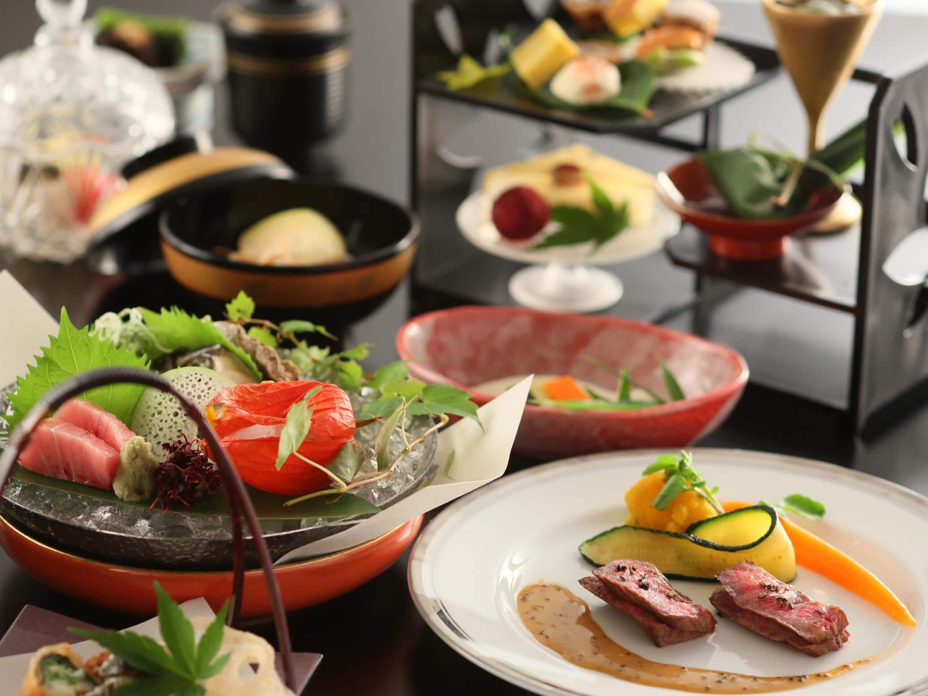 A variety of dishes including sashimi, vegetables, and meat, arranged on a table.