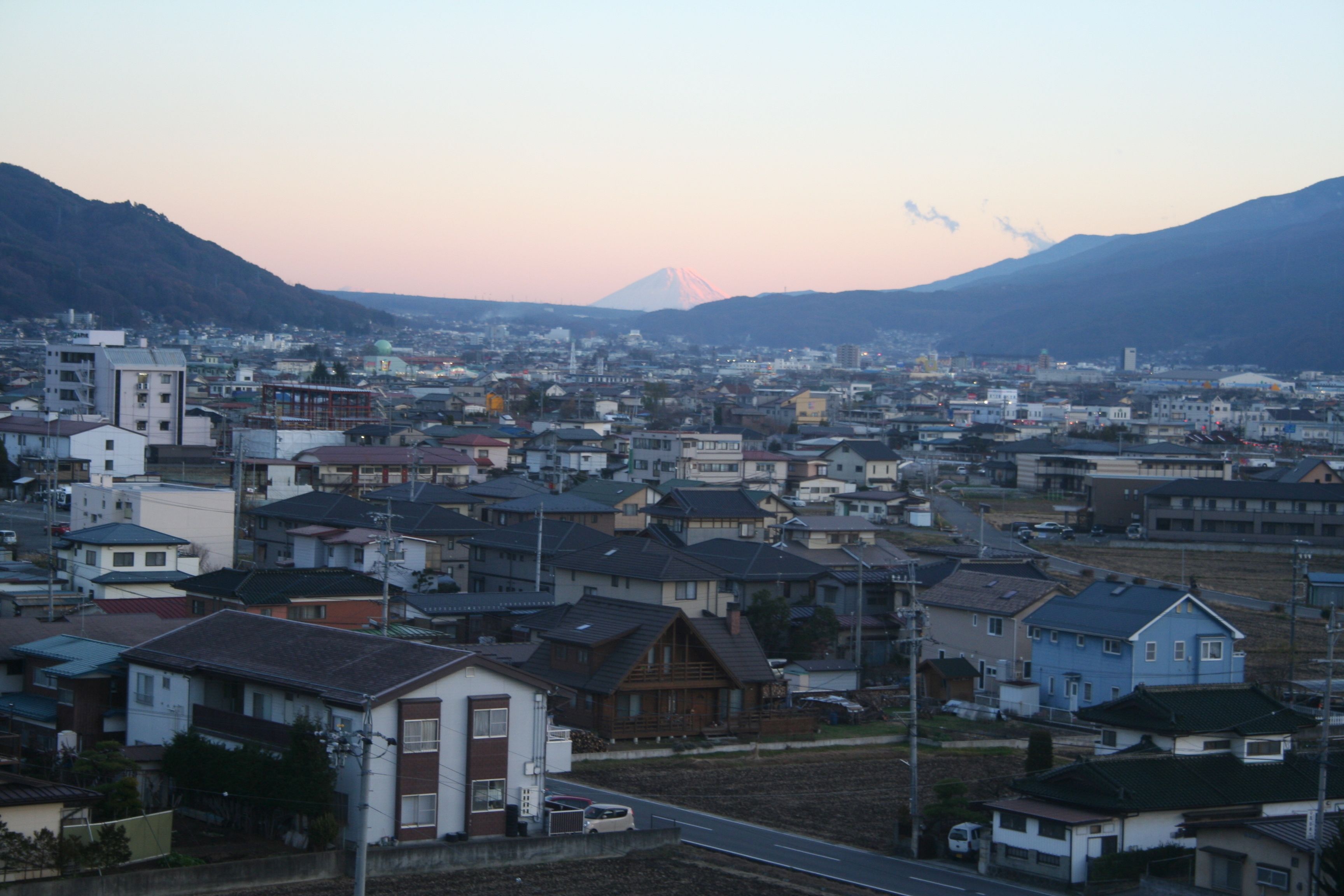 Un barrio residencial con casas, una calle y una montaña al fondo.