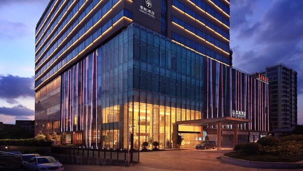 A modern hotel building with a glass facade and illuminated lines. - Yunkai Hotel (Guangzhou)