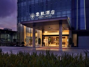 The exterior of the Unkai Hotel with a modern facade and a covered entrance area. - Yunkai Hotel (Guangzhou)