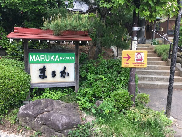 Un cartel con caracteres japoneses y una flecha que indica la dirección a la derecha.