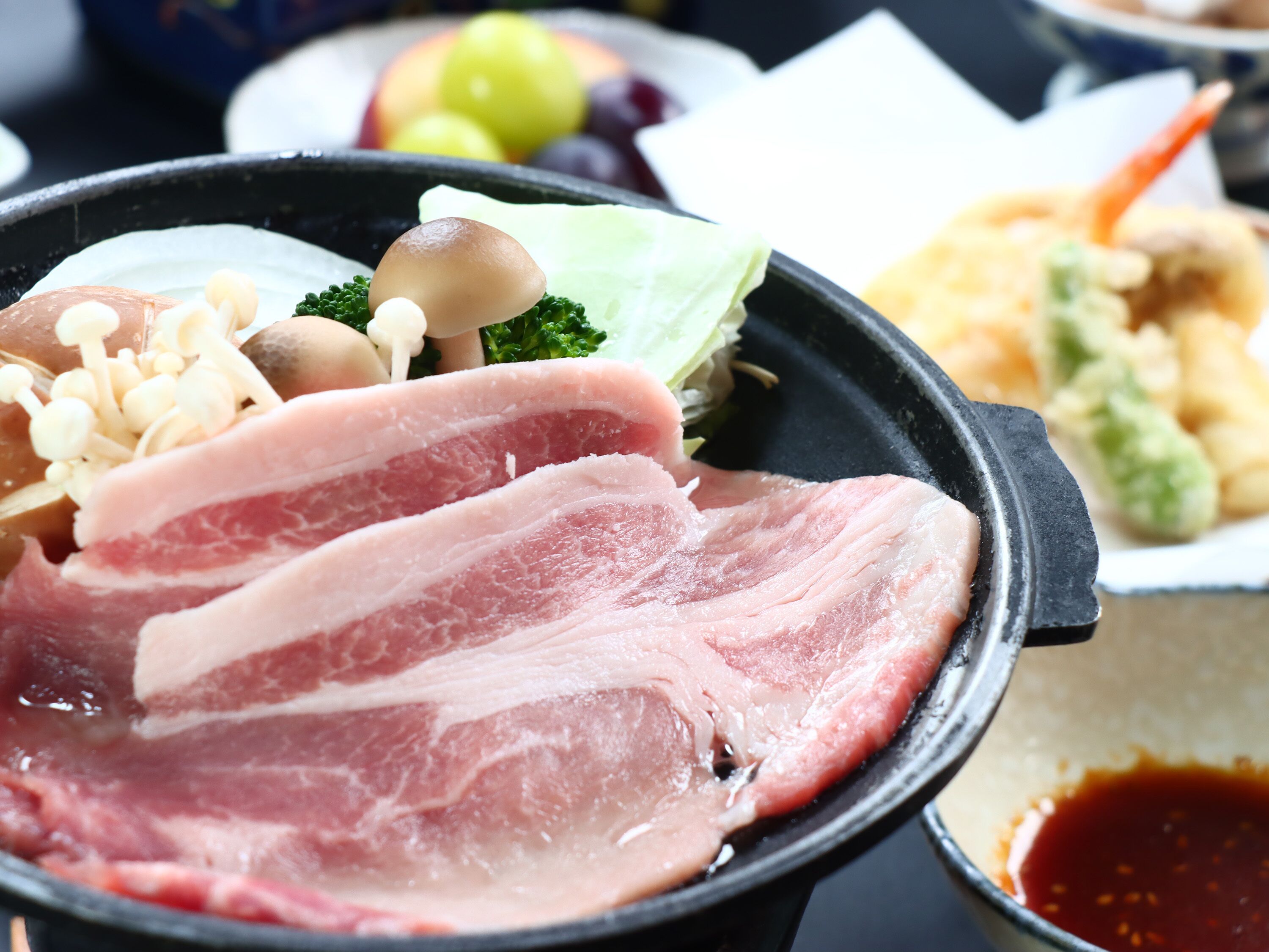 A hot pot meal with various ingredients like meat, mushrooms, and vegetables.