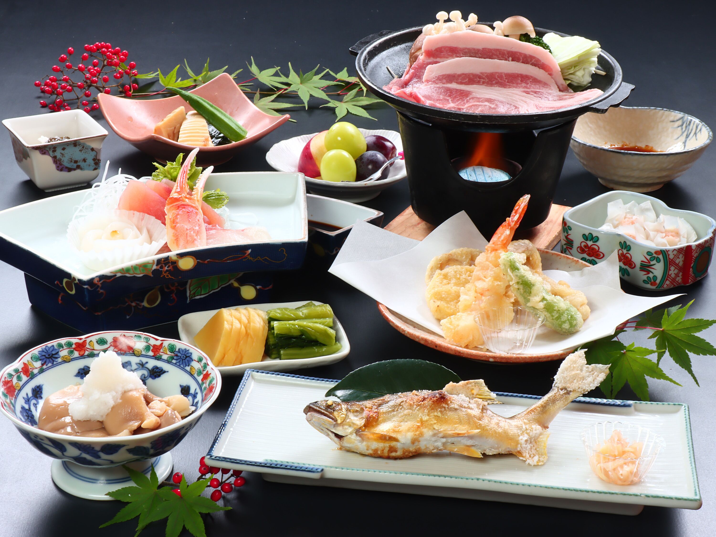 Diversos pratos japoneses, incluindo sushi, tempura e peixe grelhado, dispostos sobre uma mesa.