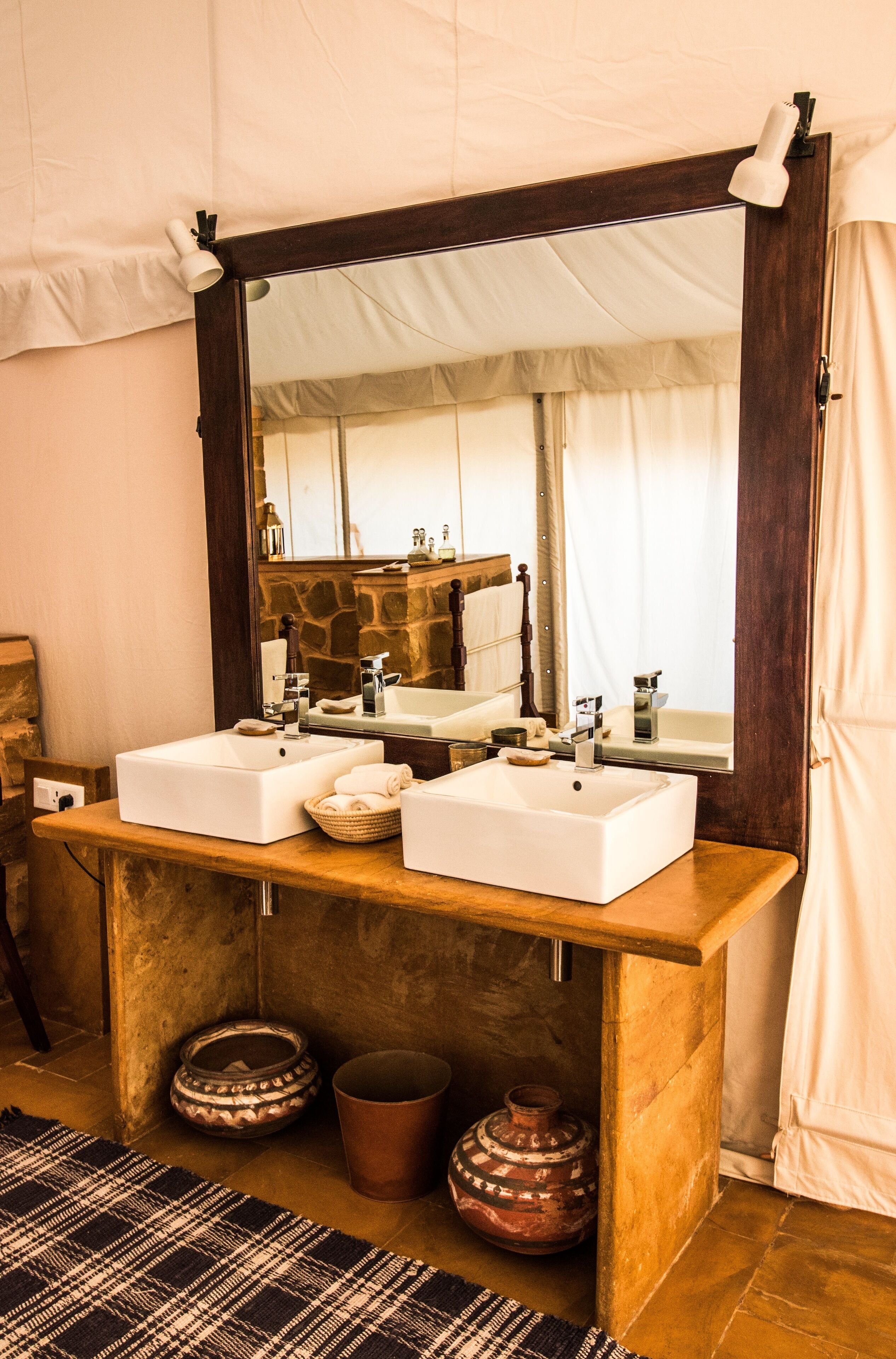 Un baño con dos lavamanos, un espejo grande y un mueble de tocador de madera.