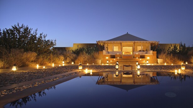 A building with a reflective pool in front, surrounded by a garden with lights. - SUJÁN The Serai, Jaisalmer - Relais & Chateaux (Jaisalmer)