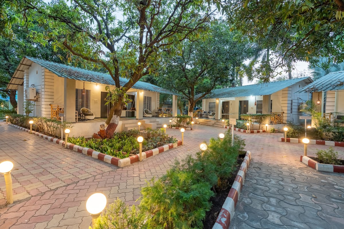 A courtyard with multiple buildings, outdoor seating areas, and well-lit pathways.