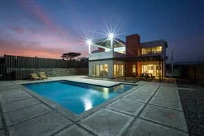 Una piscina al aire libre, tumbonas