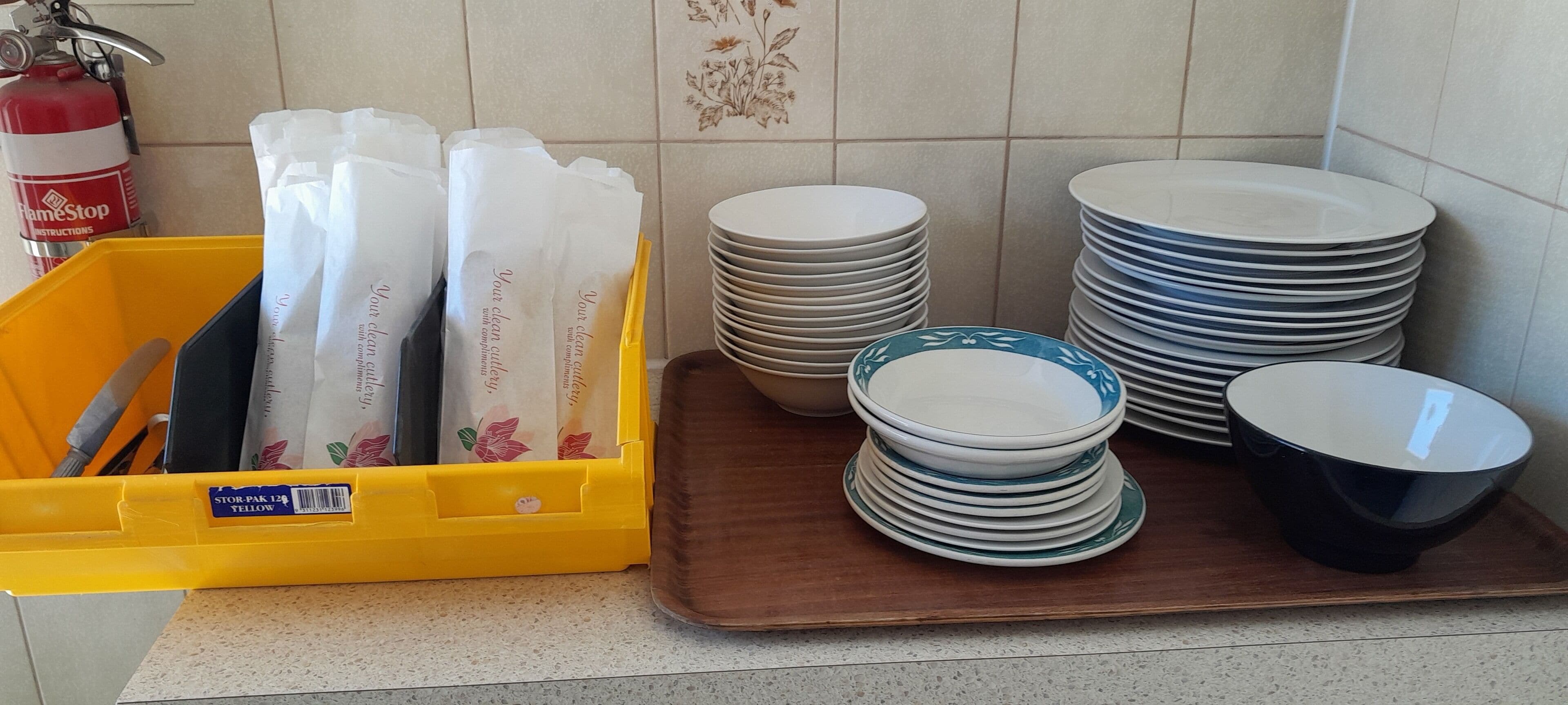 A kitchen counter with stacks of plates and paper towels.