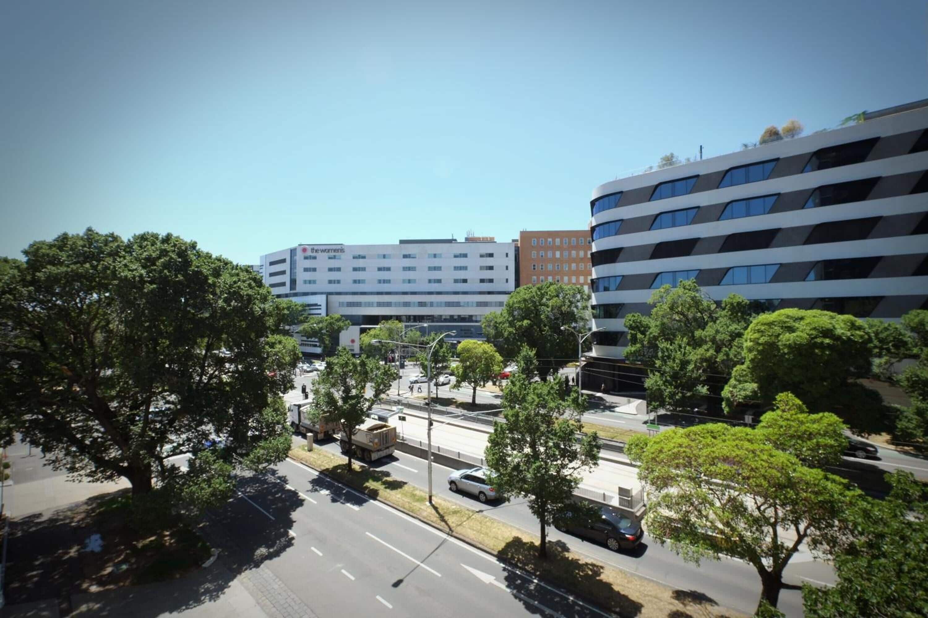 A multi-story building with a modern architectural design, featuring a mix of white and dark facade elements.