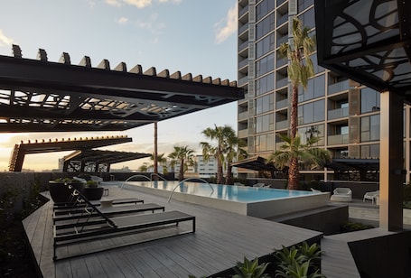 Una piscina al aire libre, sillones reclinables de piscina