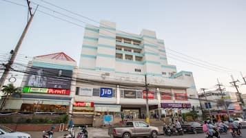 A multi-story building with various shops on the ground floor, including a buffet and a sports store.