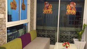 A modern living room with a sofa, a coffee table, and a window with decorative stickers. - Pitikant Place (Lam Luk Ka)