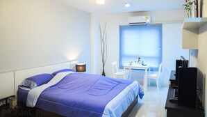 A modern hotel room with a bed, a desk, a chair, and a computer. - Pitikant Place (Lam Luk Ka)