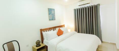 A bedroom with a bed, a nightstand, a chair, and a wall-mounted air conditioner.
