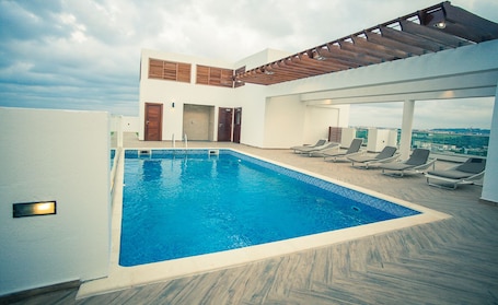 Una piscina al aire libre, sombrillas, sillones reclinables de piscina. Accra Luxury Apartments at The Gallery