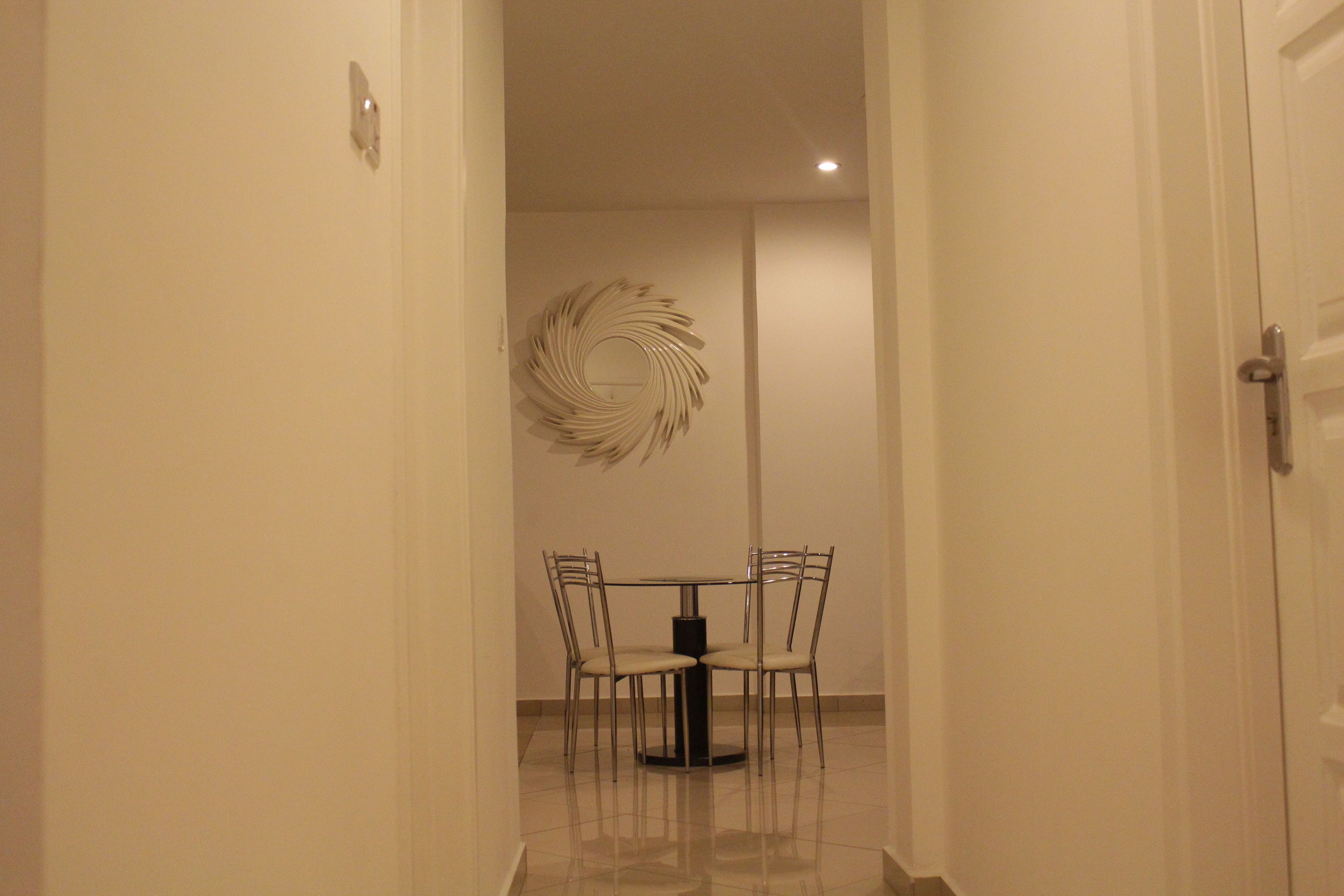 A hallway leading to a dining area with a round table and four chairs.
