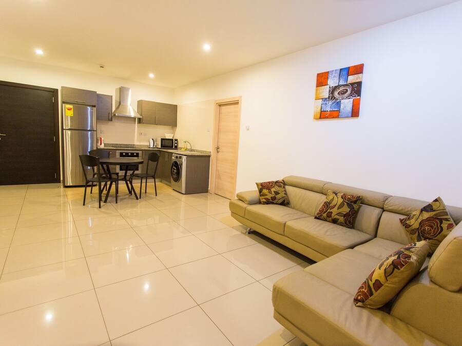 A modern kitchen with a refrigerator, microwave, and washing machine.