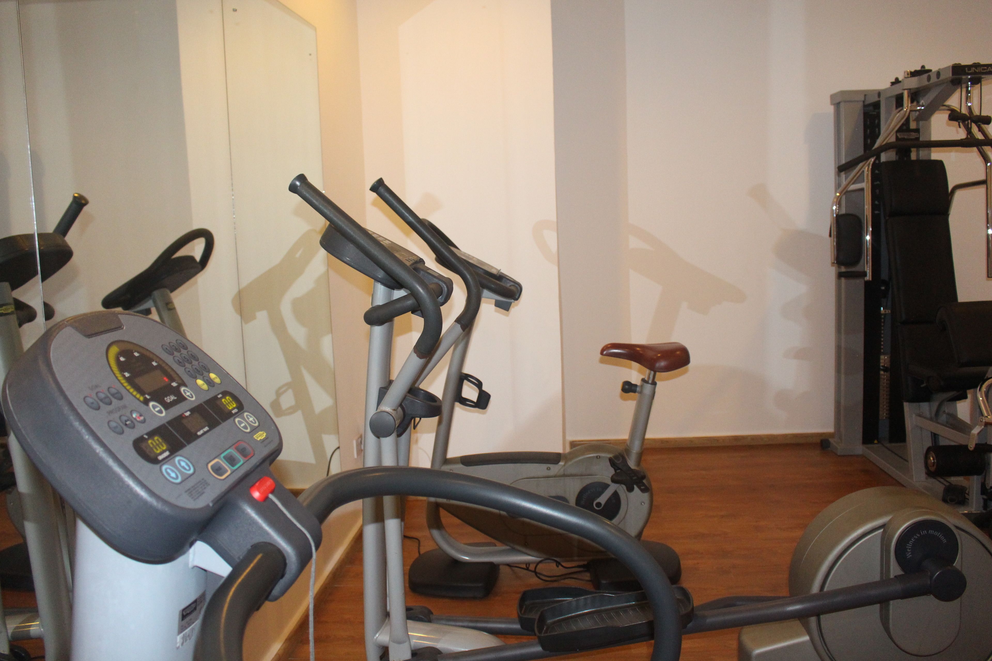 Un gimnasio con bicicletas estáticas, cinta de correr y máquinas de pesas.
