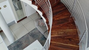 A spiral staircase with wooden steps and metal railings.