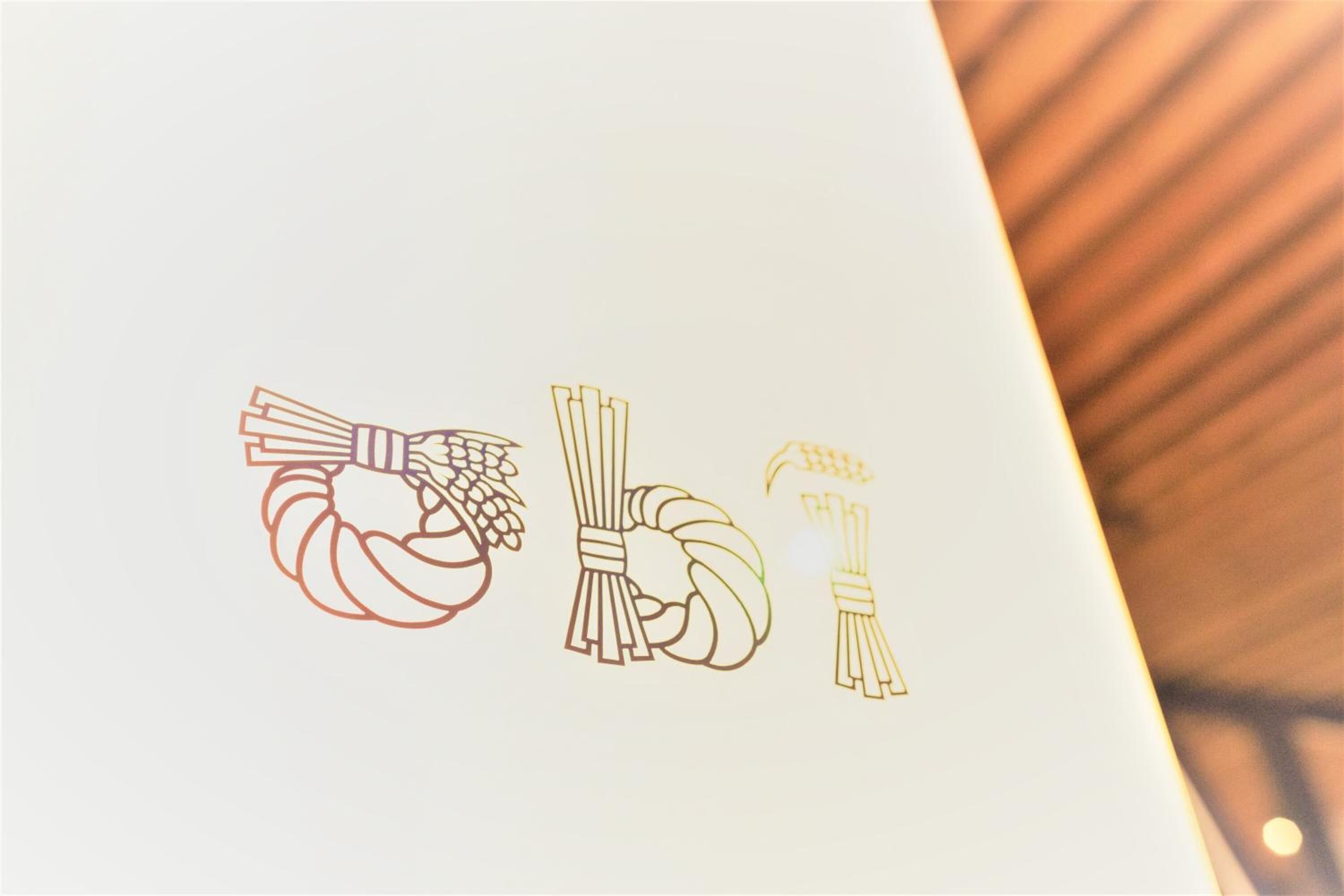 A laptop with a sticker featuring three different types of sushi rolls.