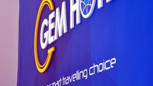 Une enseigne d’hôtel portant le nom « GEM HOTEL » et le slogan « Le choix idéal pour vos déplacements ».
