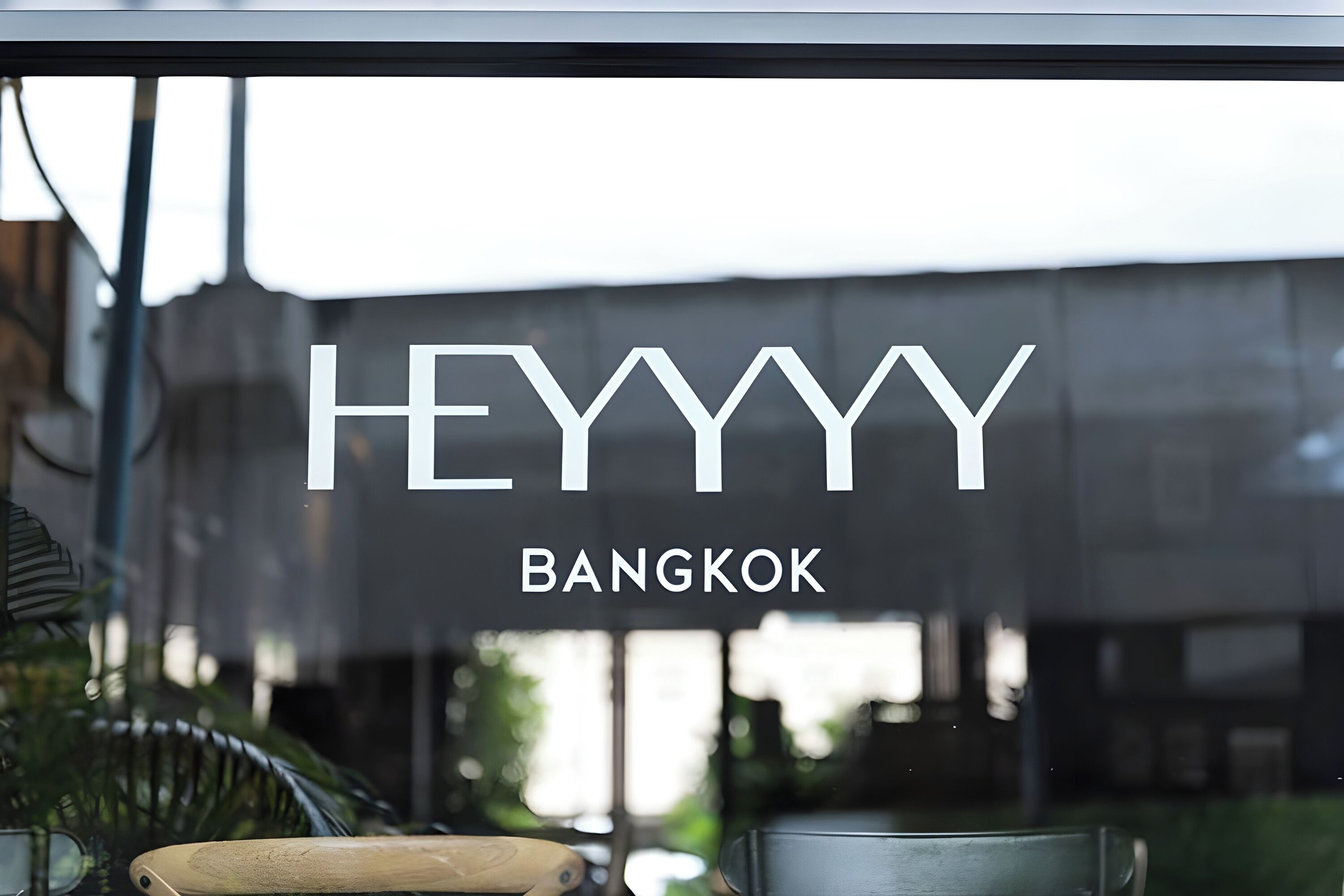 Una ventana con el texto "HEYYYY BANGKOK" que indica una ubicación.