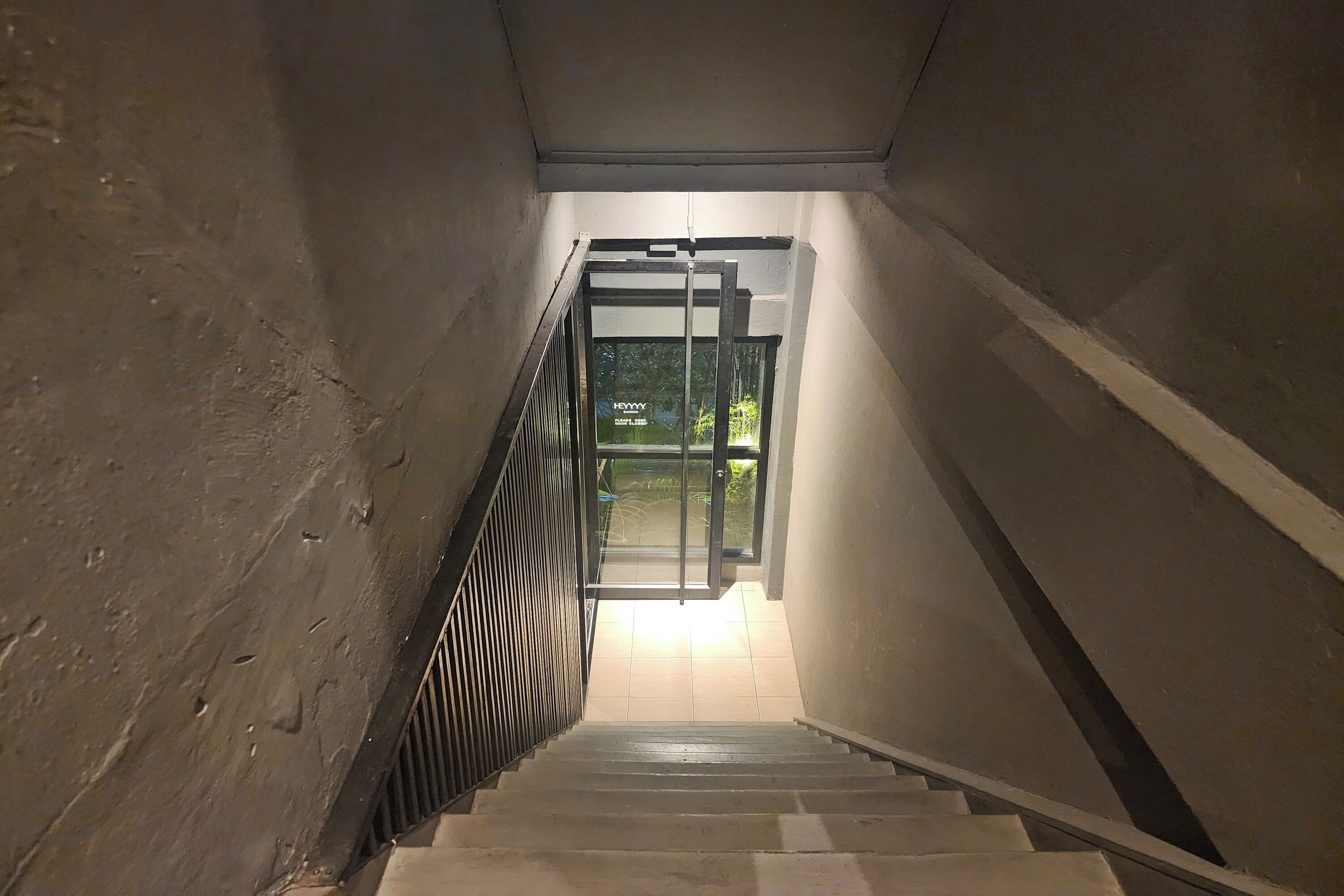 A staircase leading to a glass door with a metal frame.