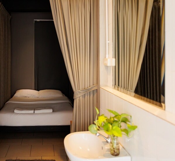 Ein modernes Badezimmer mit einem Bett, einem Waschbecken und einem Spiegel.