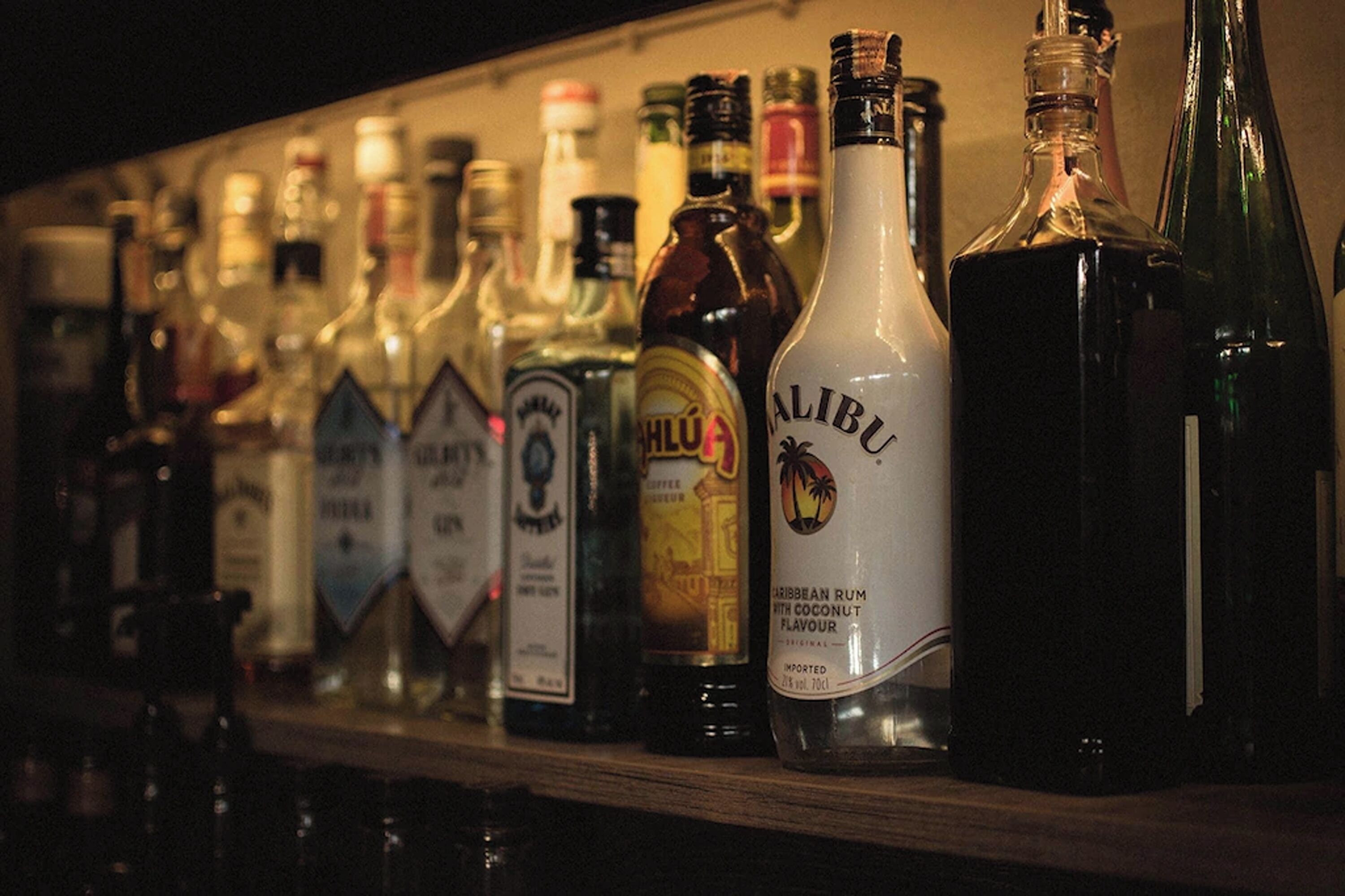 A variety of liquor bottles on a shelf.